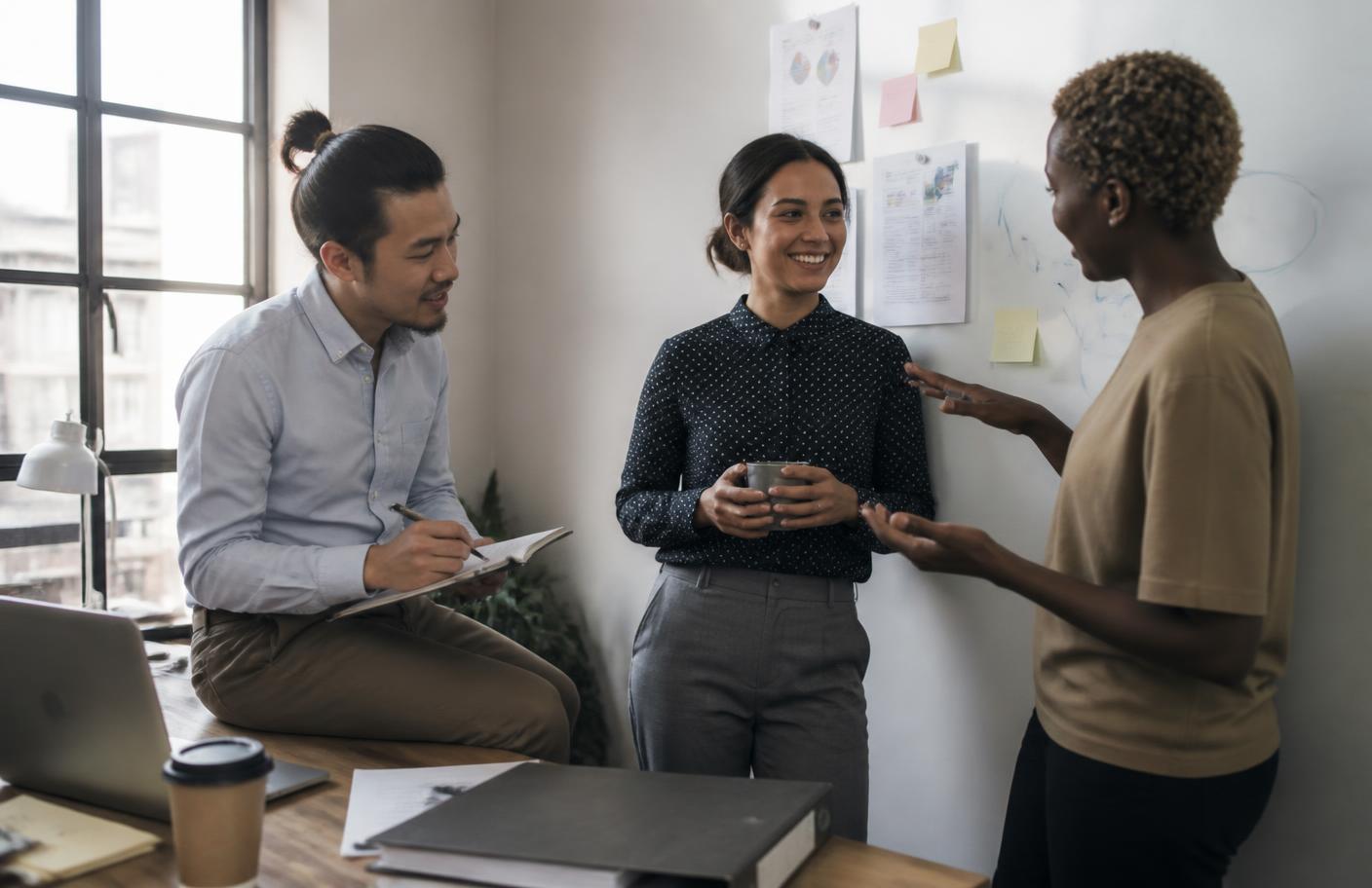 Three colleagues sharing ideas during an informal office moment